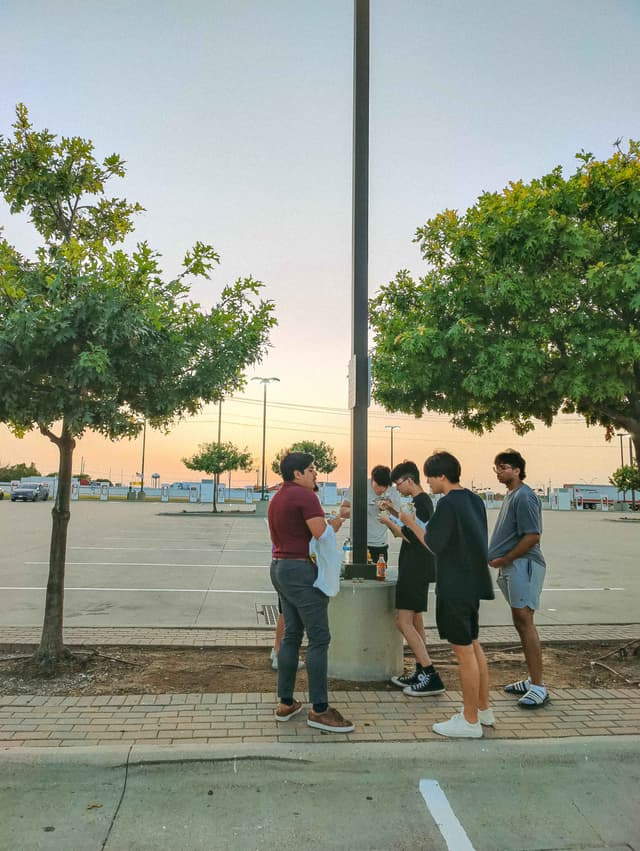 Photo of friends eating around a lamp post